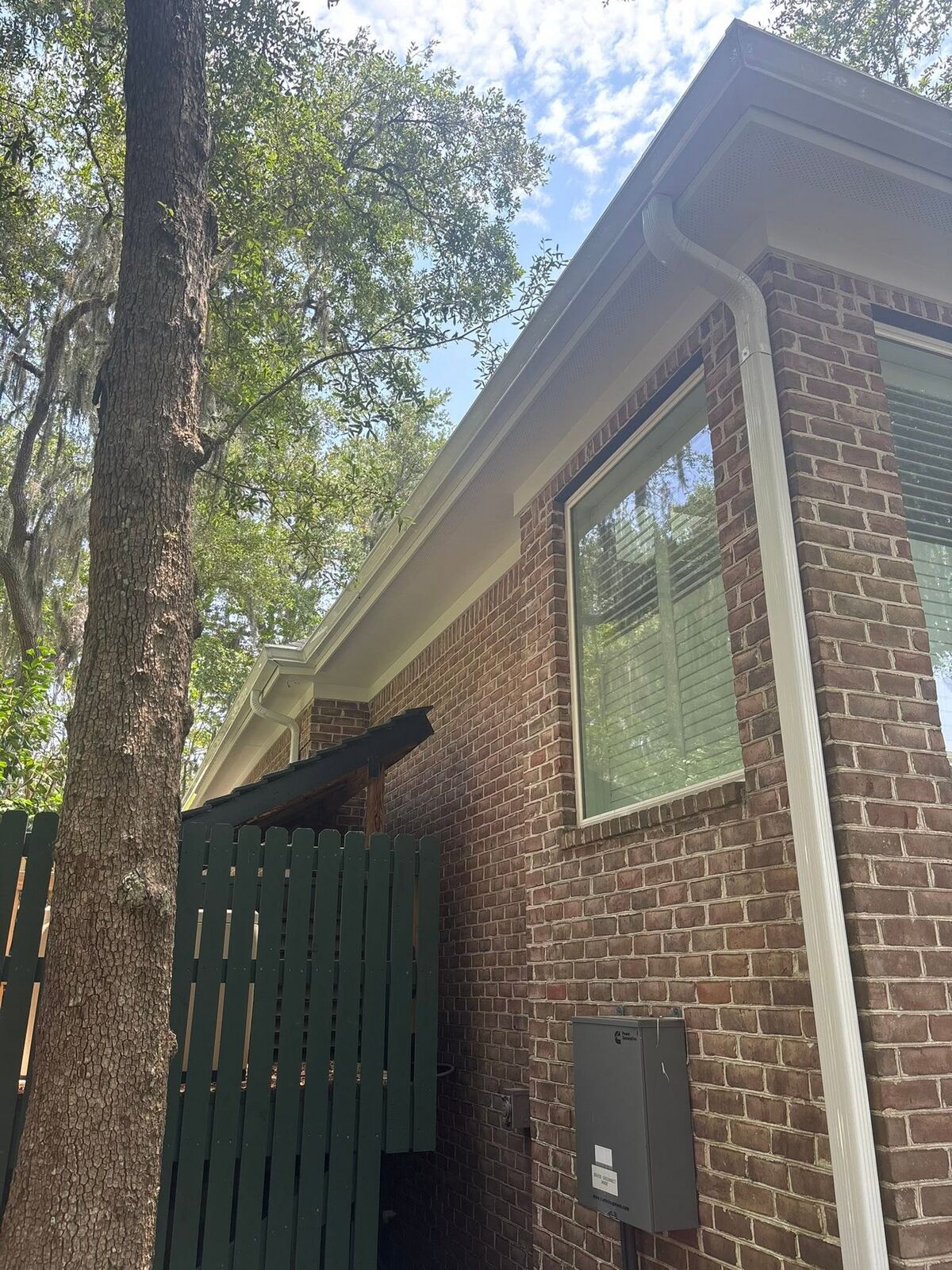White downspout routed down a red-brick column on a Lowcountry home